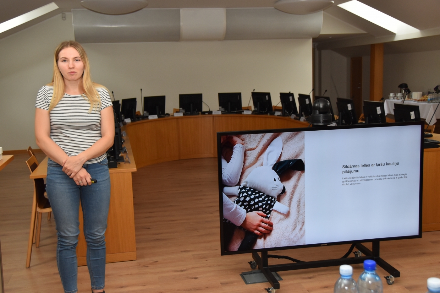 Prezentētāja ar prezentāciju uz ekrāna